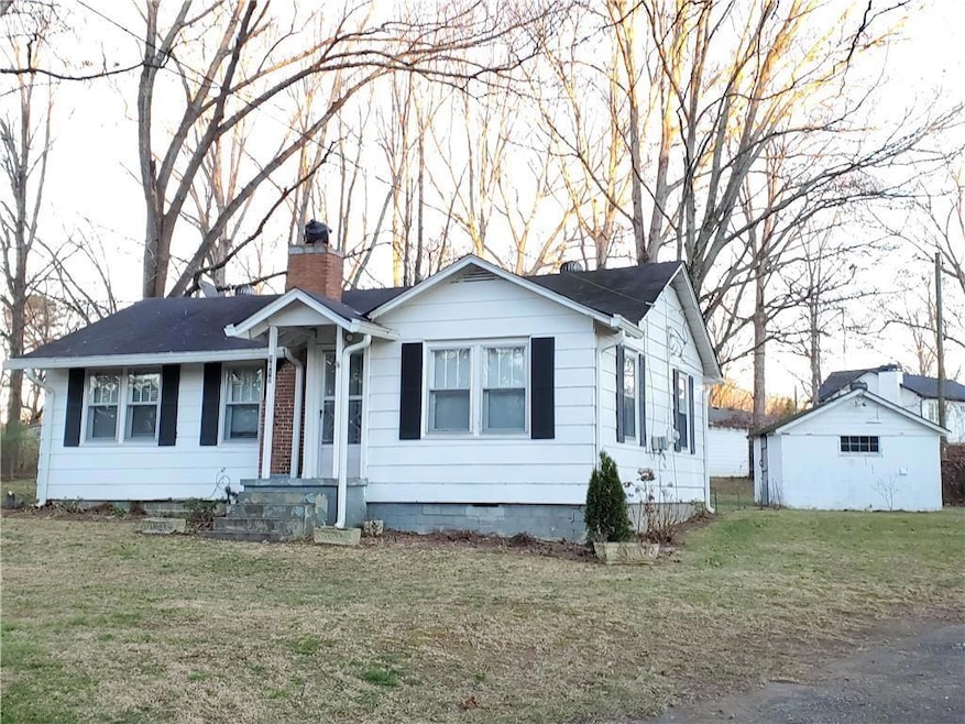 Single story home featuring a chimney, a front lawn, and crawl space