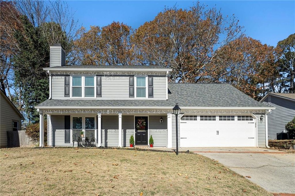 View of property with a garage, a front lawn, and 