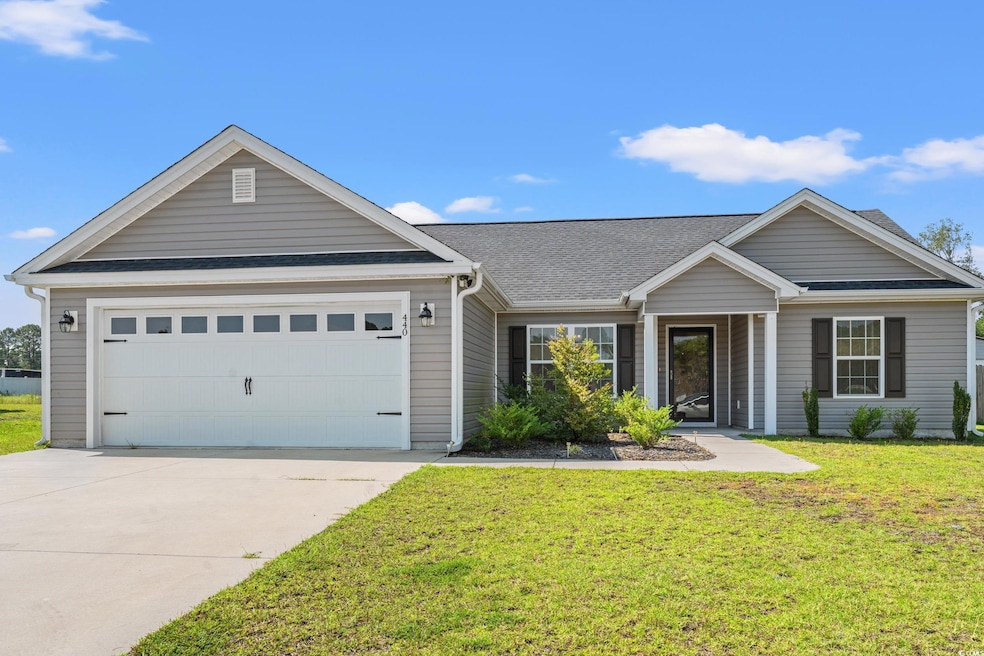 Single story home featuring a front yard and a gar