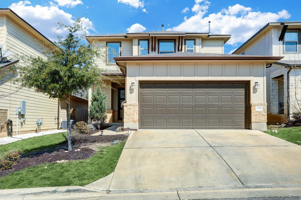 View of front of house with board and batten siding, driveway, a garage, and stone siding