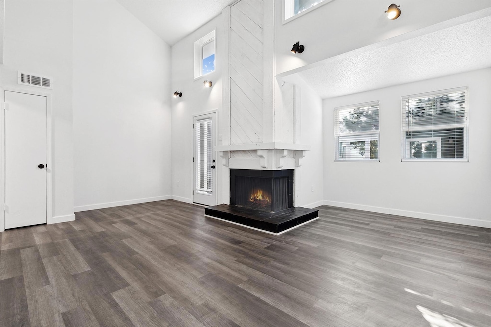 Unfurnished living room featuring a textured ceili