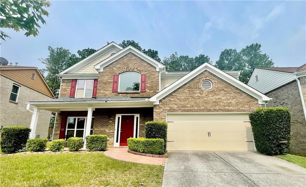 View of front facade featuring brick siding, driveway, an attached garage, and a front lawn
