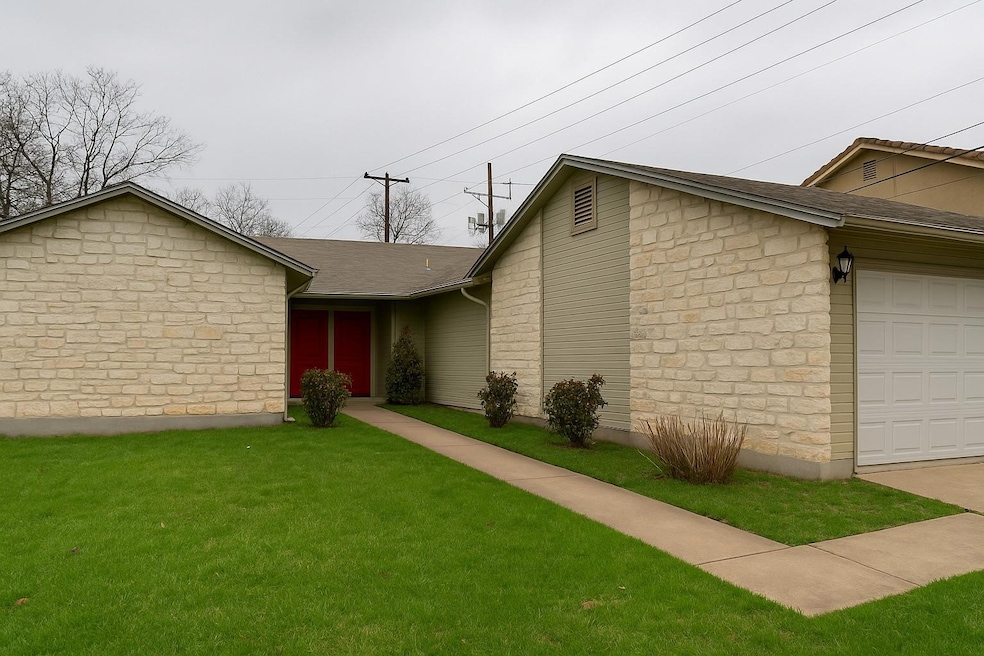 Ranch-style house with stone siding, a garage, a 