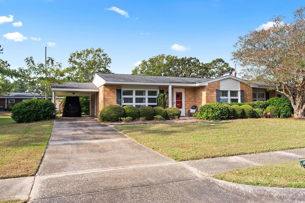 Ranch-style home with a front lawn and a carport