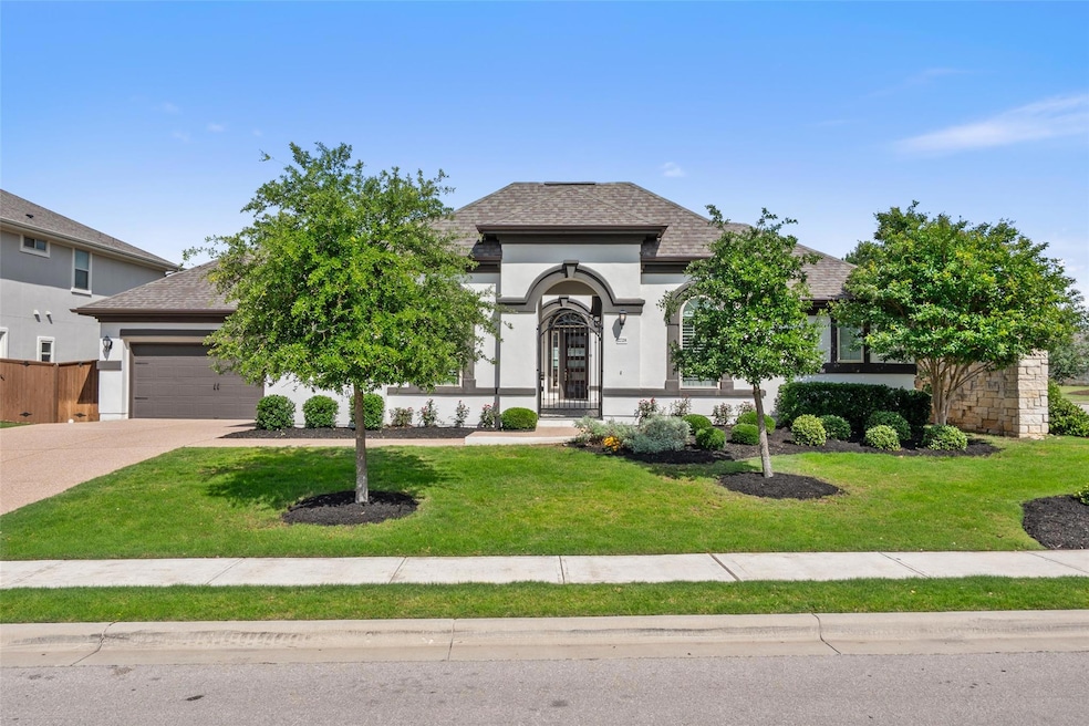 View of front facade with stucco siding, driveway