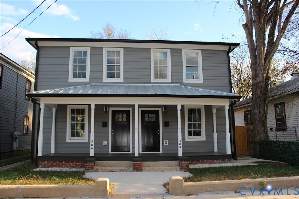 View of front of house with covered porch, a standing seam roof, and a metal roof