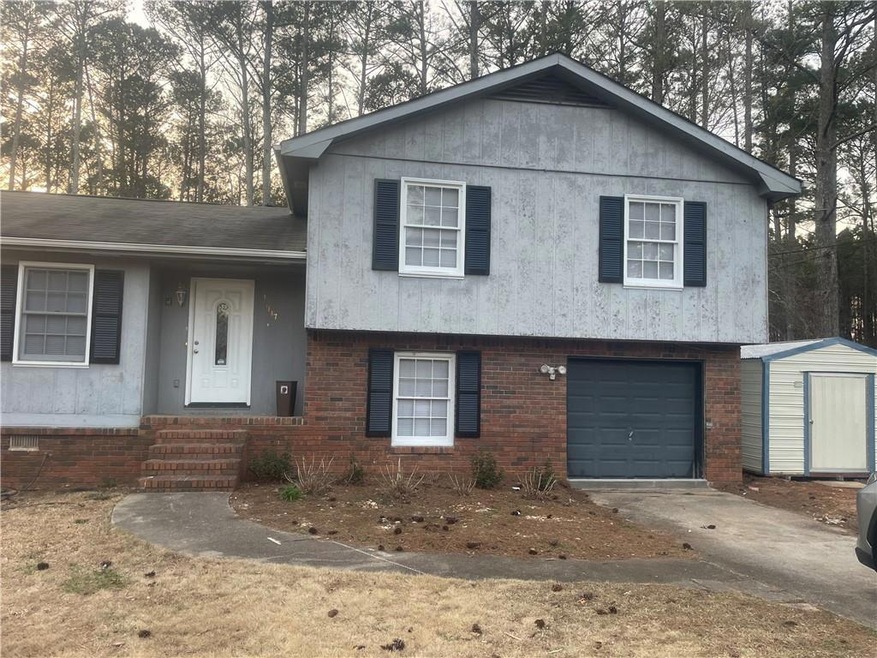 Split level home featuring a storage shed and a ga