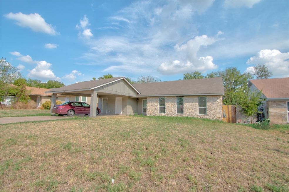 Ranch-style home with stone siding, a carport, an