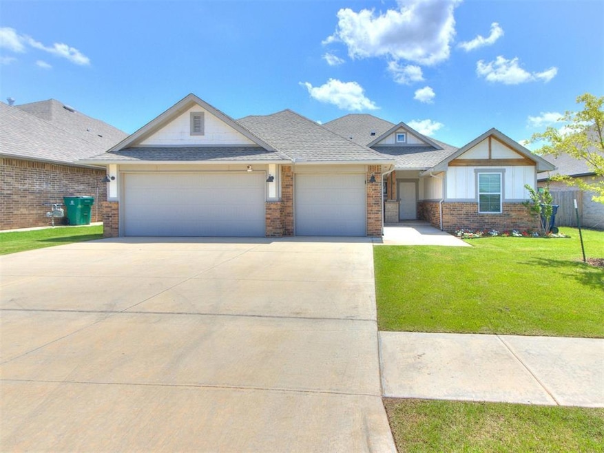 View of front of home featuring a garage, concrete driveway, a front lawn, brick siding, and roof with shingles