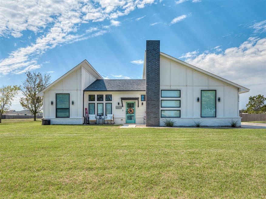 View of front of house featuring board and batten siding and a front yard