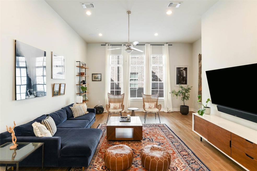 Living room featuring visible vents, a ceiling fa