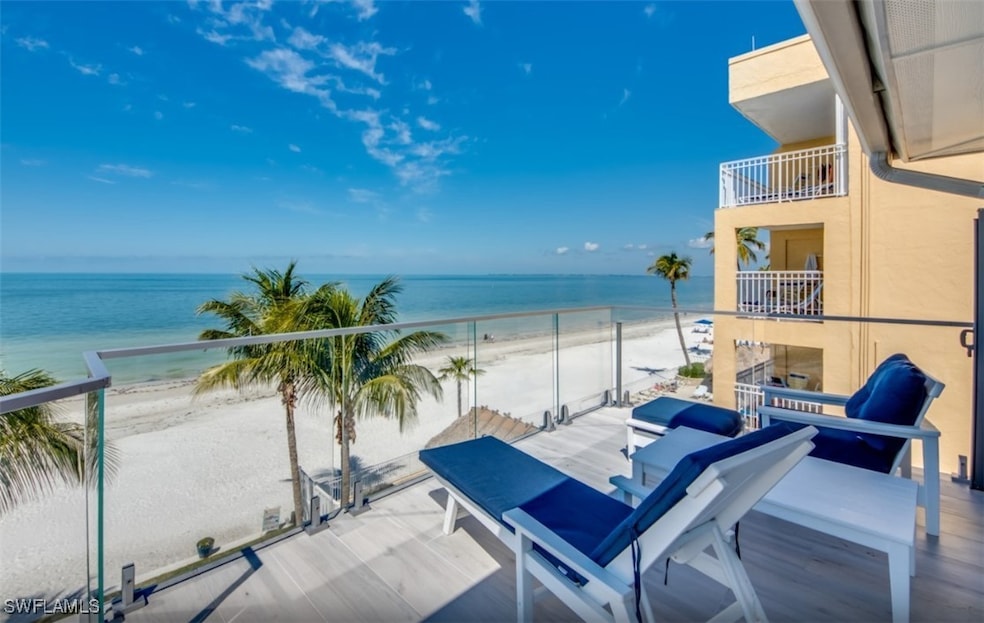 Balcony featuring a view of the beach and a water