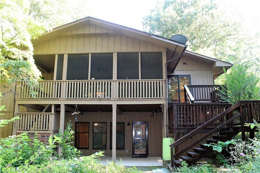 Back of home, screened in porch stairs exiting on either side, new outdoor carpet, and just stained deck, and painted concrete. Privacy, great gardeners yard, foresty.
