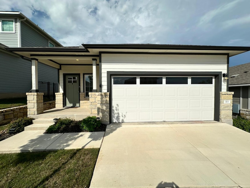 View of front facade with driveway, a porch, a ga