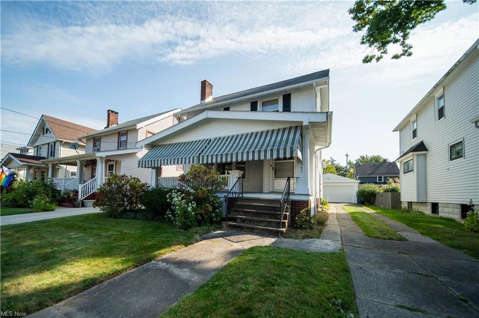 View of front of property featuring a front yard, garage, and a porch