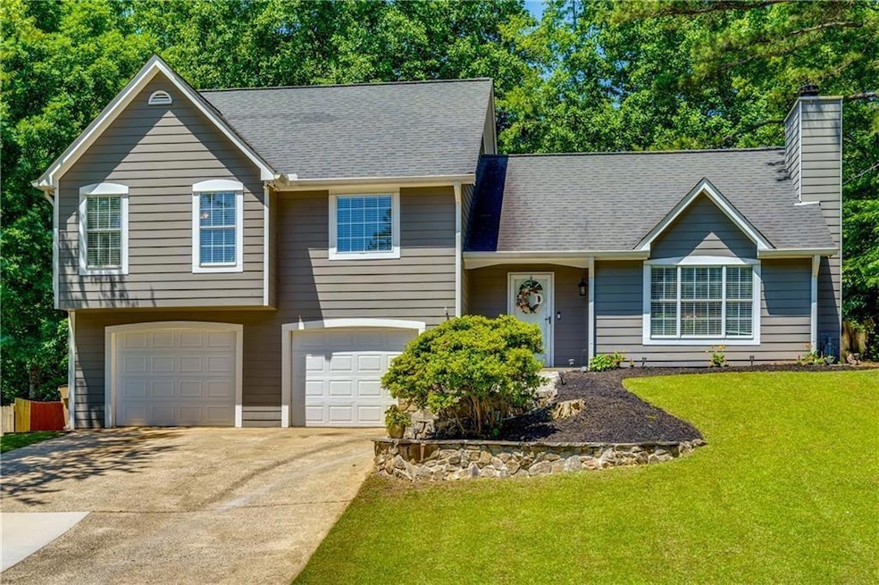 Split level home with a garage and a front lawn