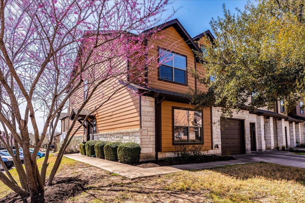 View of front of property with an attached garage, stone siding, and driveway