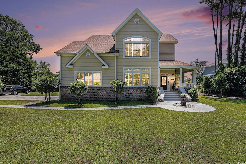 Traditional-style home with a yard, covered porch, and a shingled roof