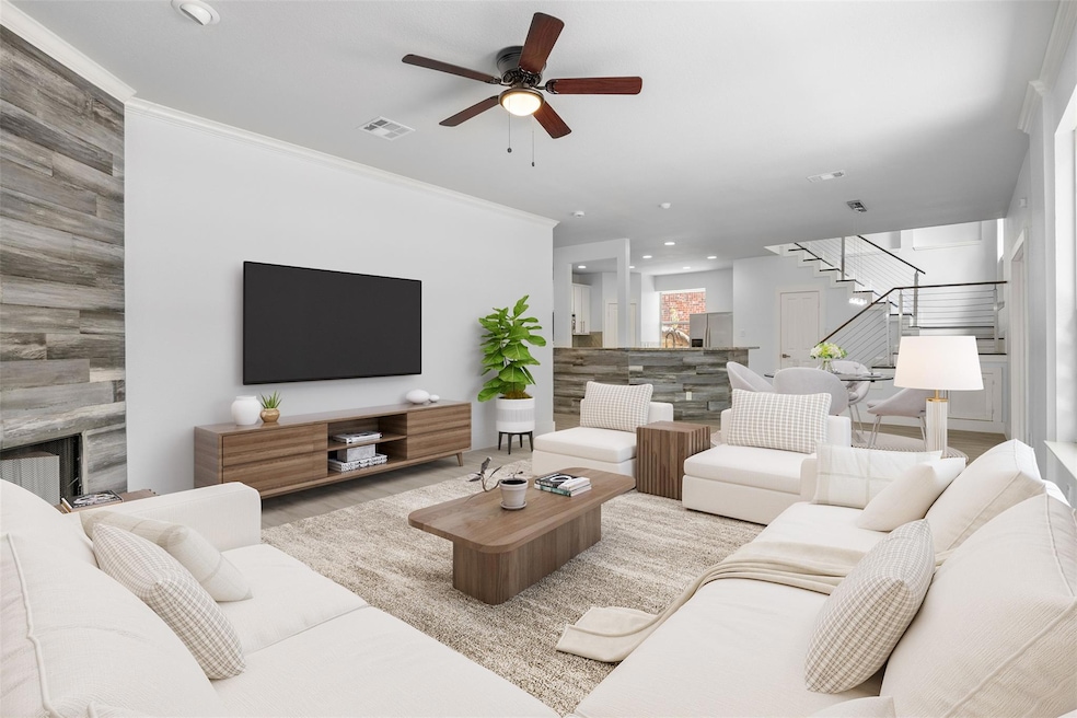 Living room featuring stairs, a ceiling fan, rece