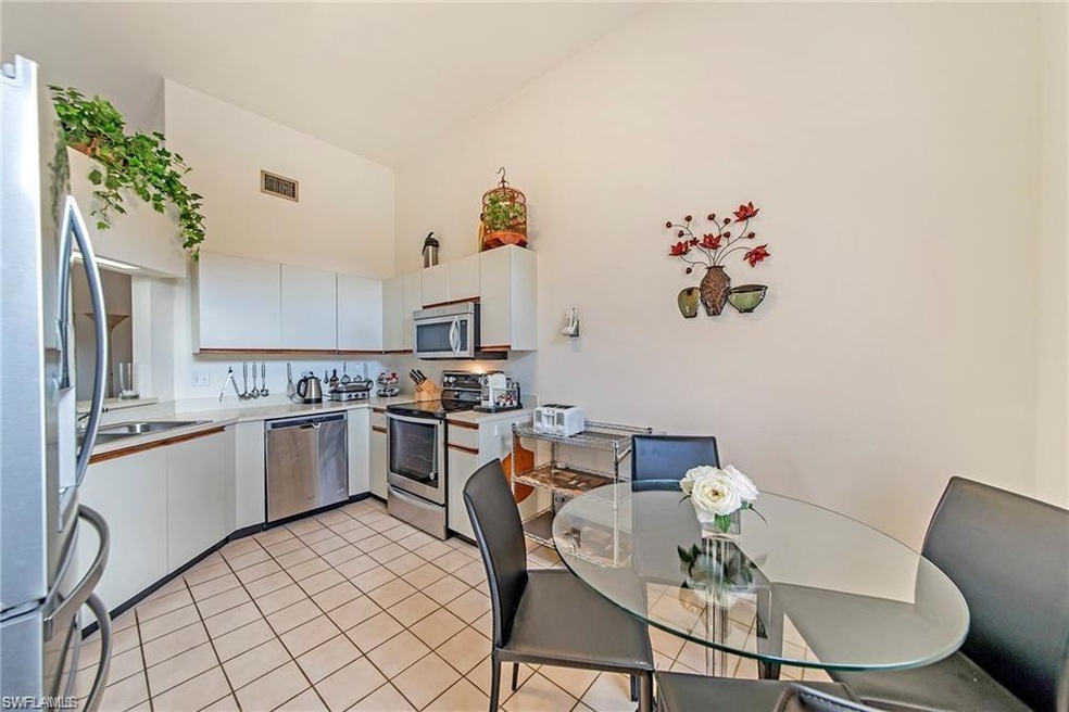 Kitchen with white cabinets, high vaulted ceiling,