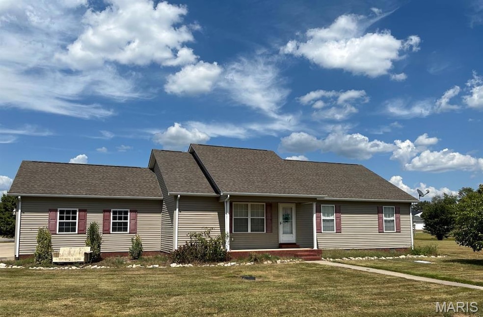 View of front facade with roof with shingles, a front yard, and a porch