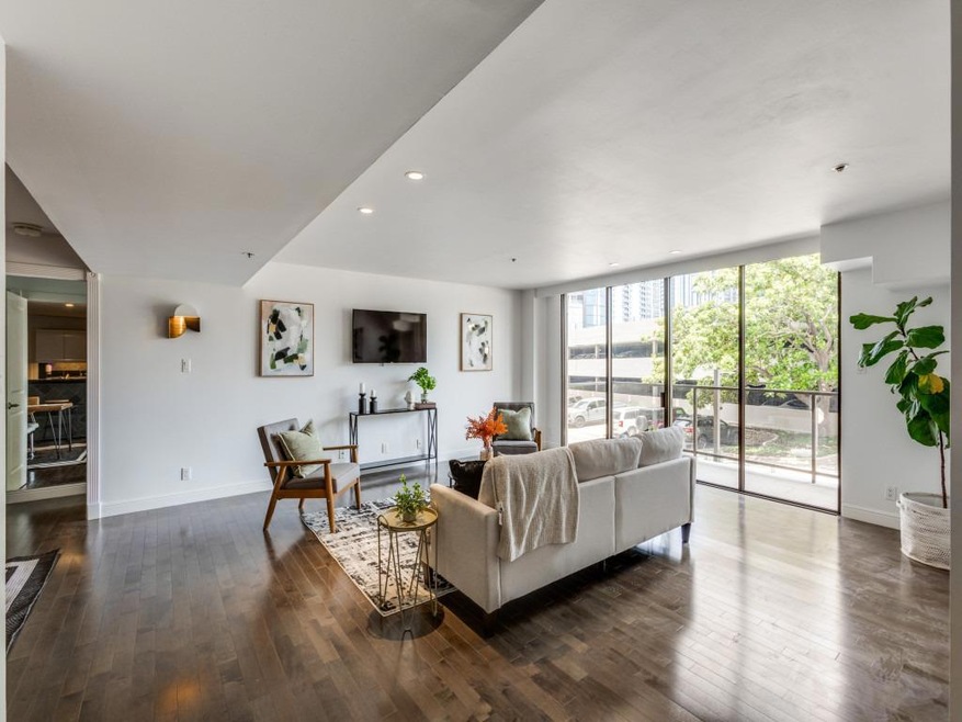 Living area with dark wood-style floors, recessed