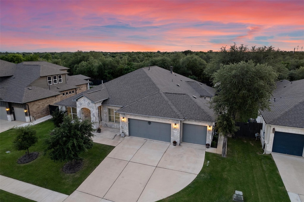 View of front facade featuring stone siding, a ga