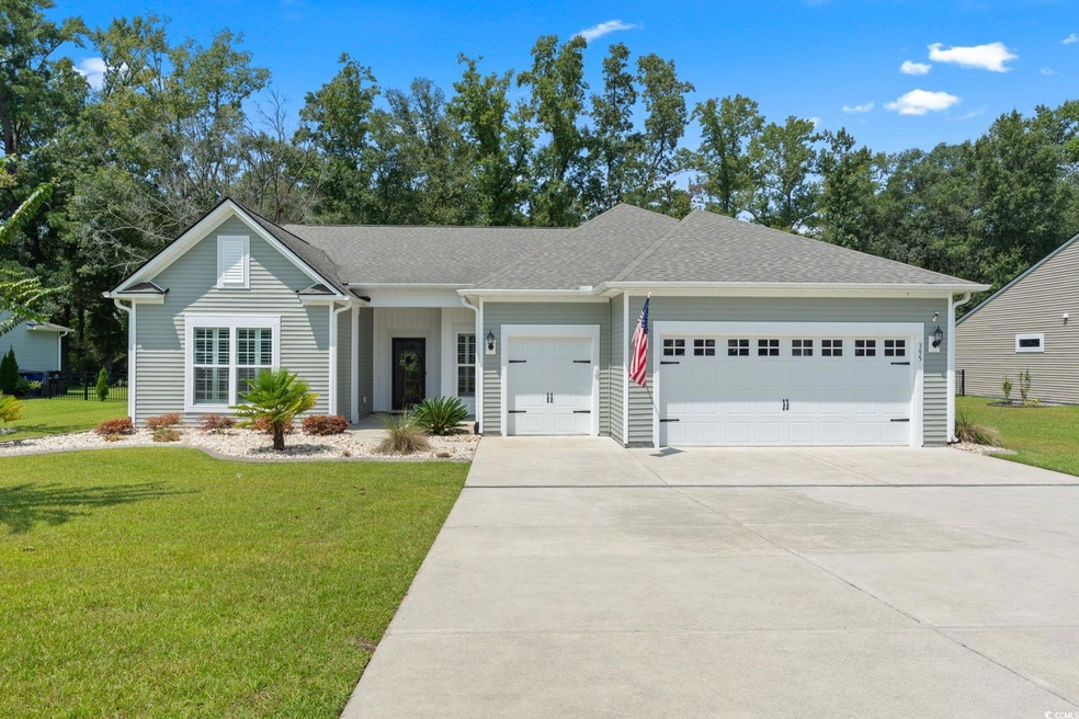 Ranch-style house with a garage and a front lawn