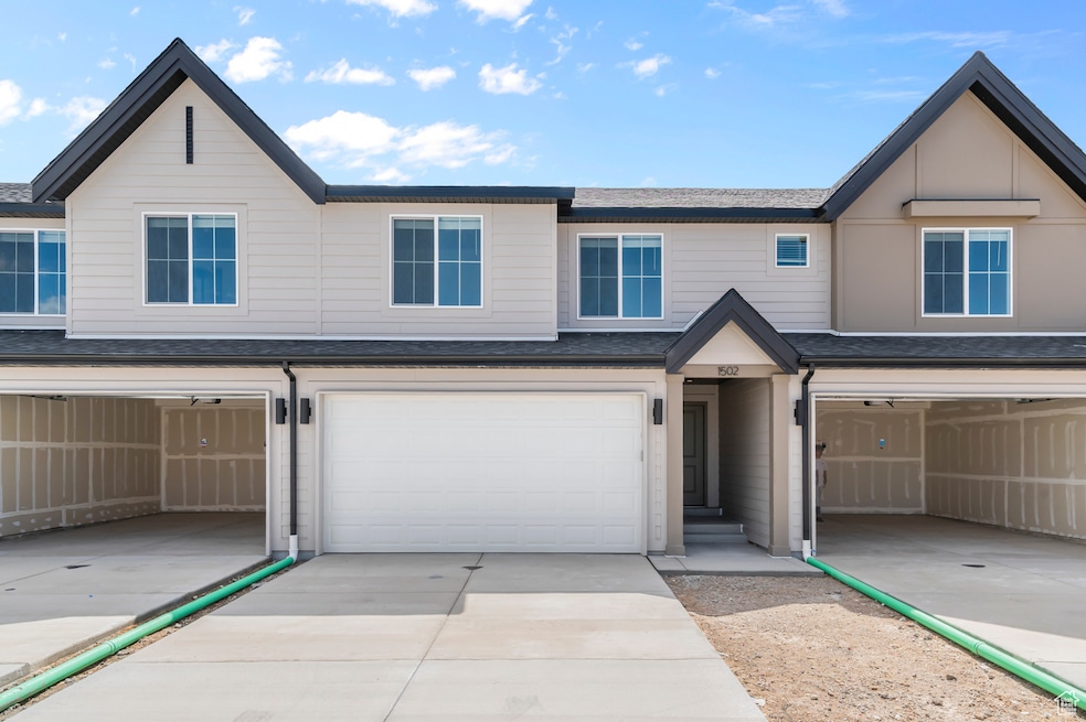 View of front of house with concrete driveway, a shingled roof, and a garage