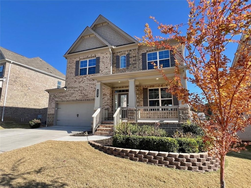 Craftsman inspired home featuring a porch, driveway, a garage, and a front lawn