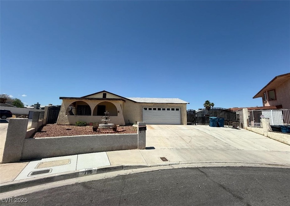Ranch-style home featuring a gate, concrete drivew