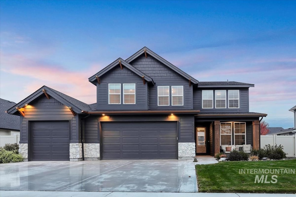 View of front of property featuring stone siding, driveway, and an attached garage