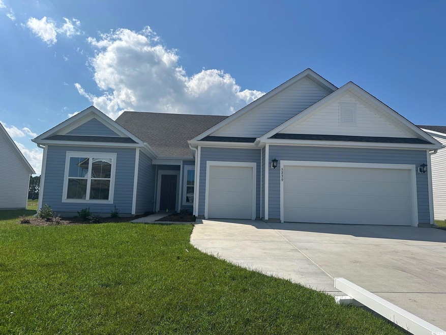 View of front of home with a front yard and a gara