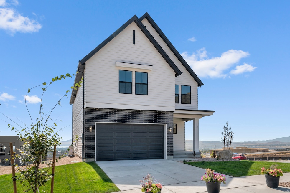 View of front facade featuring a front yard, a porch, an attached garage, driveway, and a mountain view