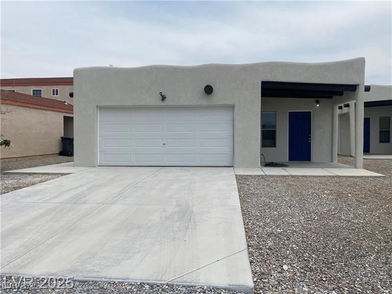 Pueblo-style unit A with driveway, stucco siding,