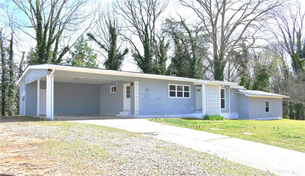 View of front facade with concrete driveway, a car