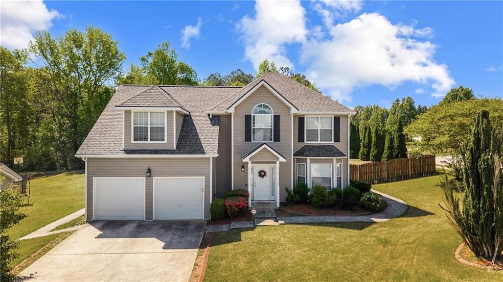 Traditional home with fence, a front lawn, roof wi