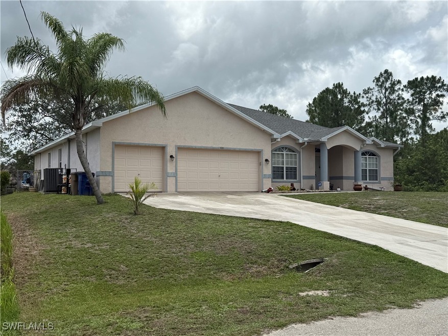 Ranch-style house with a garage, driveway, stucco