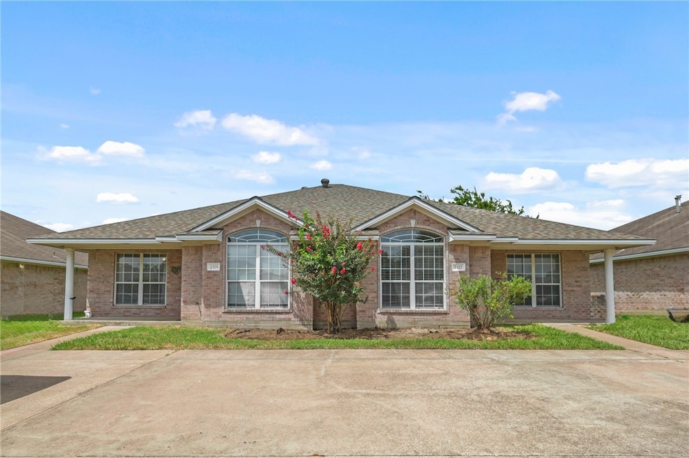 Ranch-style house with a shingled roof and brick s