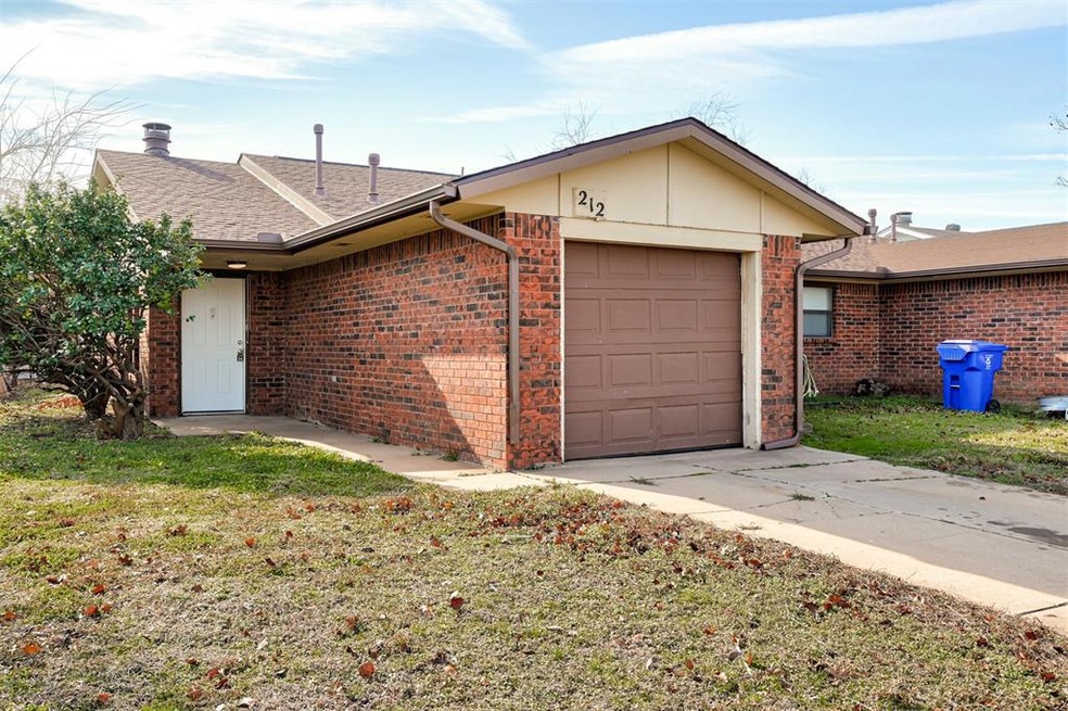 View of side of property with a garage and a lawn