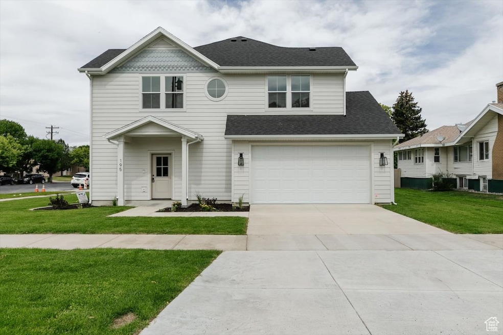 View of front of property featuring a front lawn, concrete driveway, a shingled roof, and a garage
