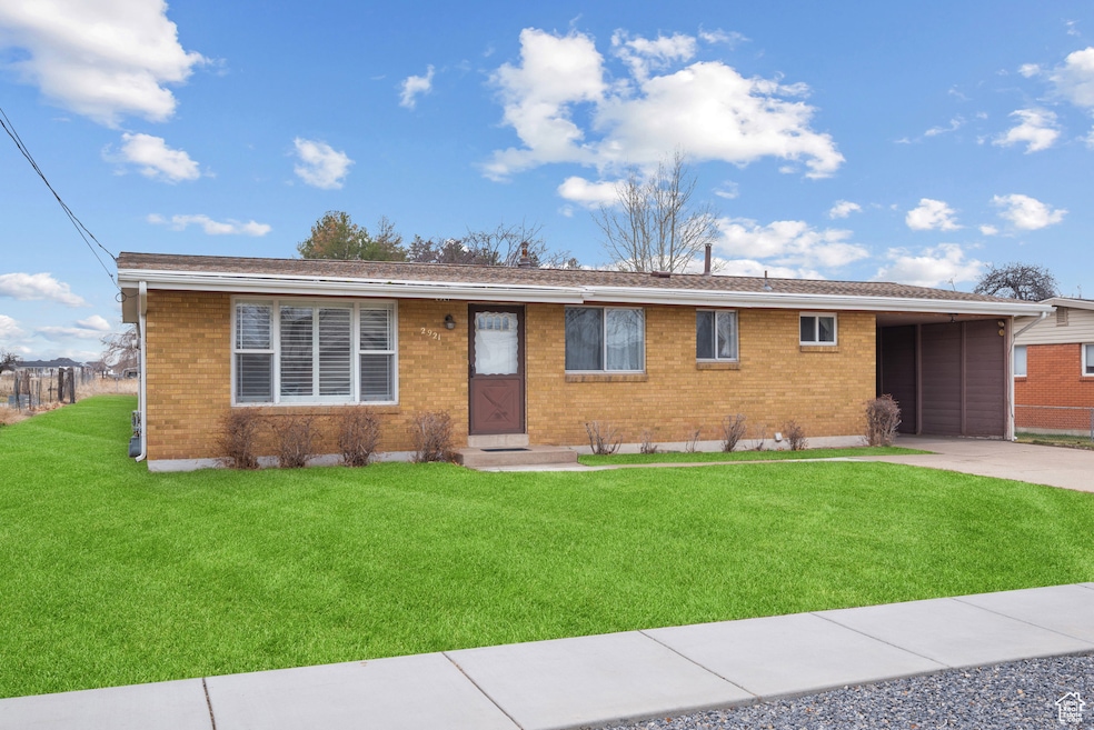 Ranch-style house featuring brick siding, an attached carport, concrete driveway, and a front lawn