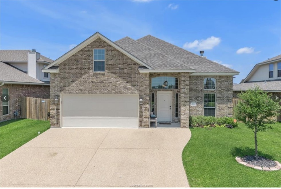 View of front facade with brick siding, driveway, a garage, and a shingled roof