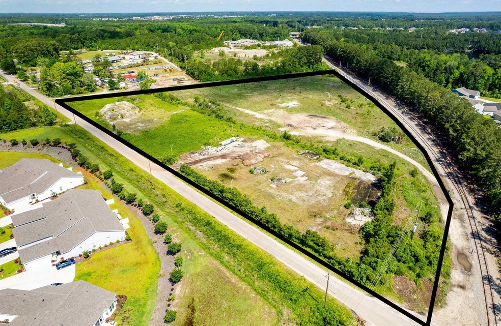 Aerial view of residential area featuring a heavily wooded area and property boundaries highlighted