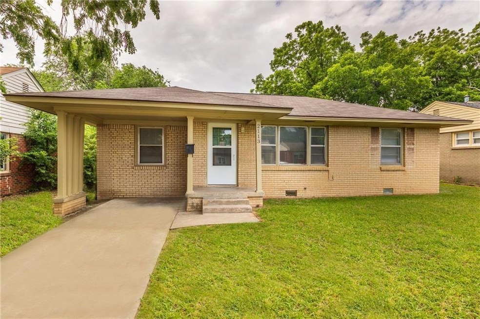 View of front of home featuring crawl space, brick siding, driveway, and a front yard