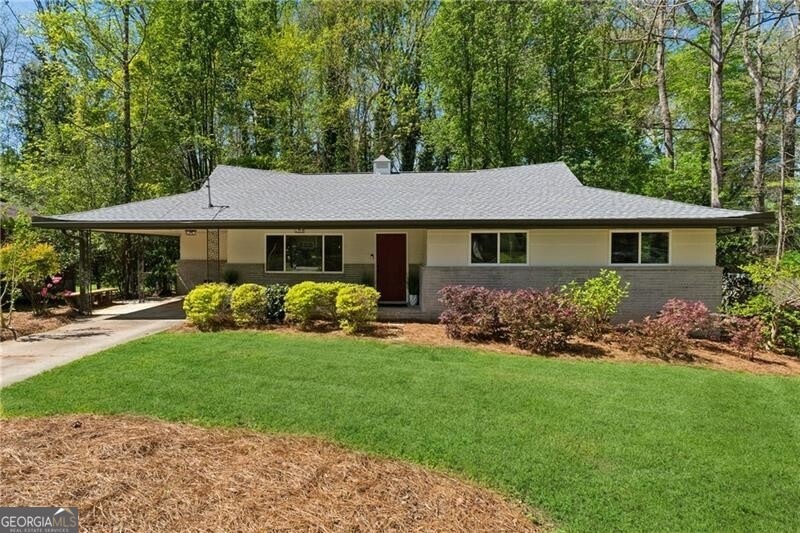 Ranch-style house with a carport and a front lawn