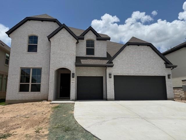 French provincial home with brick siding, concret