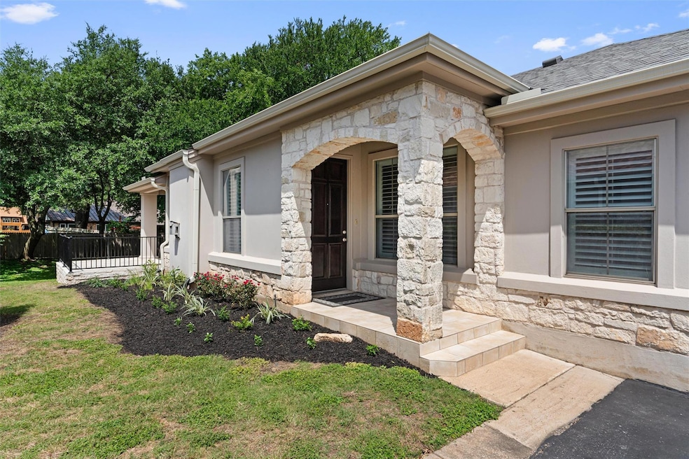 Entrance to property with stone siding, covered p