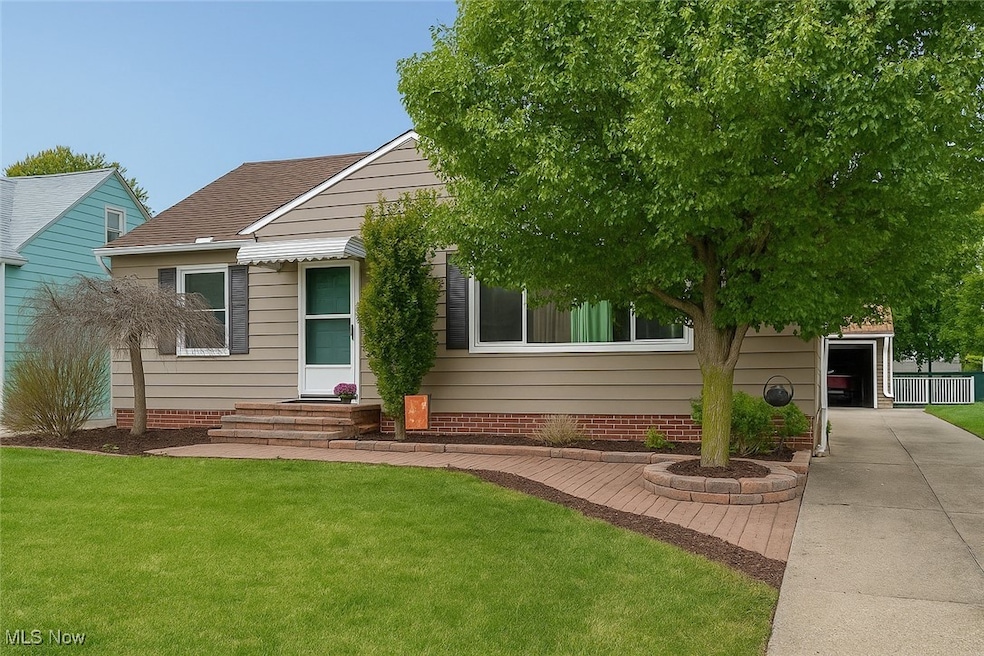 View of front of home with a front lawn and roof with shingles