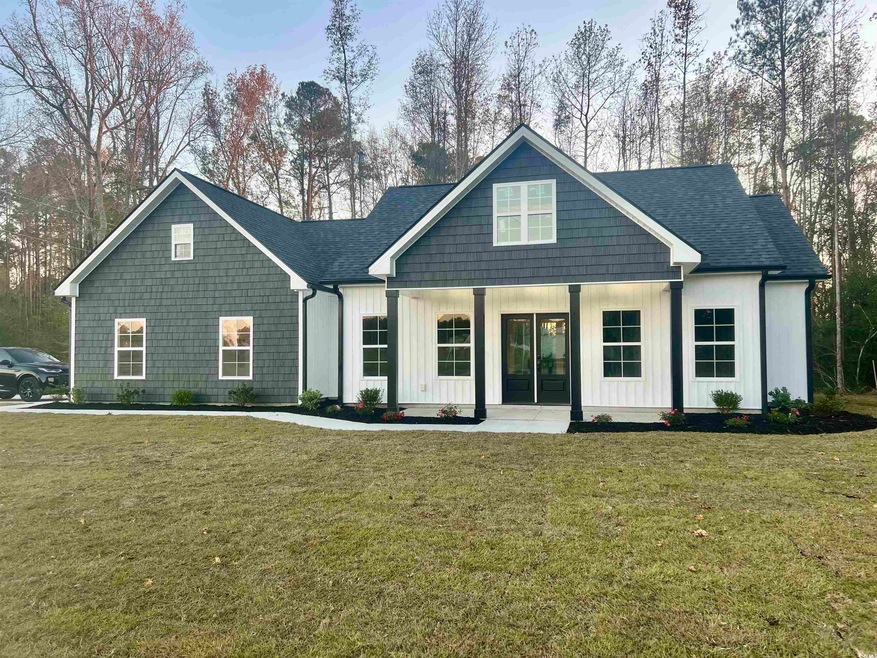 View of front of house with a porch and a front ya